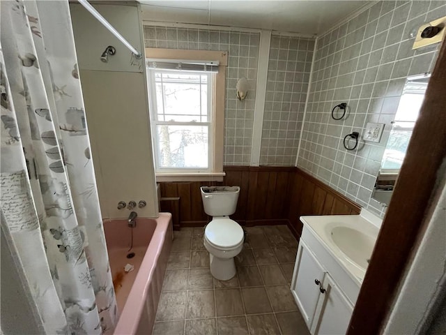 bathroom featuring shower / bath combo, a wainscoted wall, toilet, tile patterned floors, and vanity