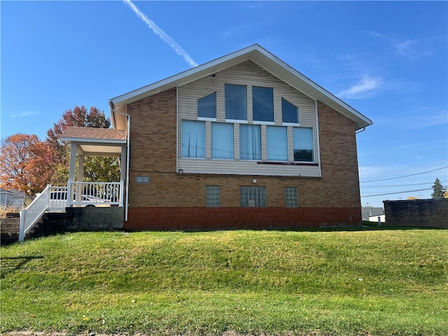 view of side of home featuring covered porch and a yard