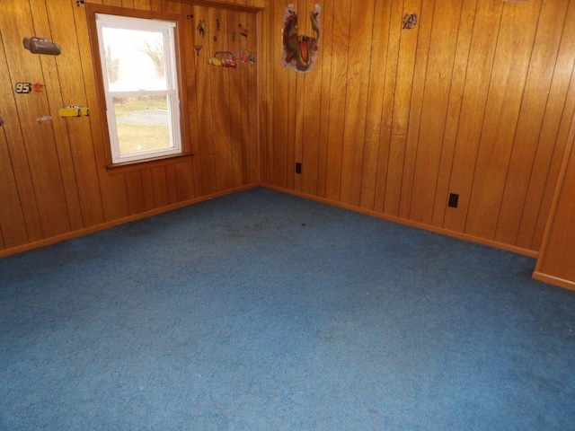 carpeted empty room with wooden walls