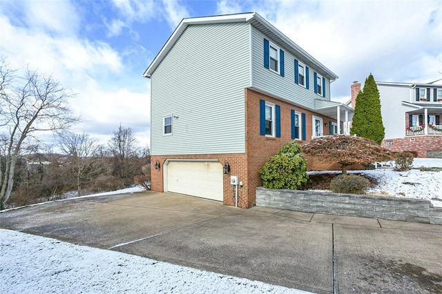 view of snowy exterior featuring a garage