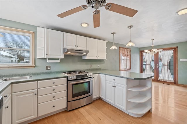 kitchen with stainless steel range with gas cooktop, pendant lighting, white cabinets, kitchen peninsula, and light hardwood / wood-style flooring