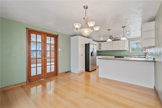 kitchen with light hardwood / wood-style flooring, white cabinetry, stainless steel refrigerator with ice dispenser, decorative light fixtures, and french doors