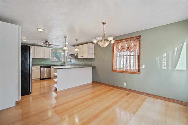 kitchen with white cabinets, hanging light fixtures, kitchen peninsula, stainless steel appliances, and light wood-type flooring