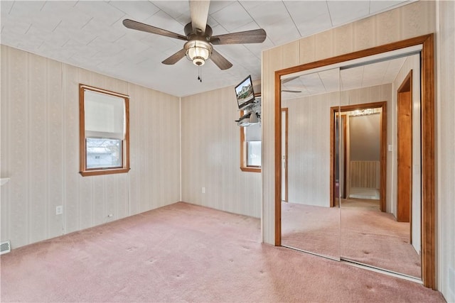 empty room with light colored carpet and ceiling fan