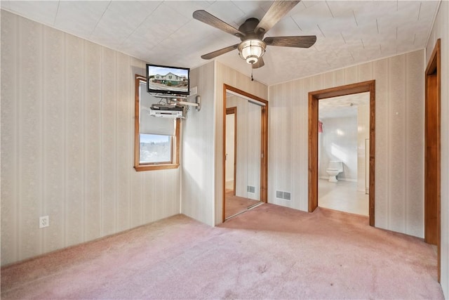 unfurnished bedroom featuring carpet, connected bathroom, ceiling fan, and a closet