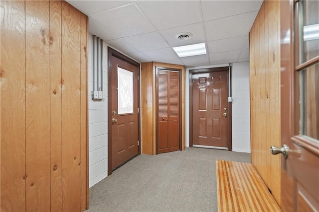 interior space with light colored carpet and wooden walls