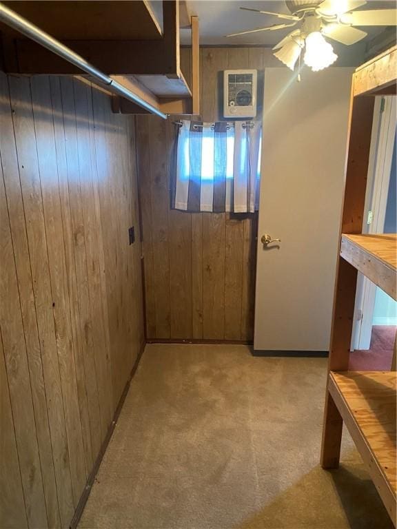 interior space featuring ceiling fan, light carpet, and wood walls