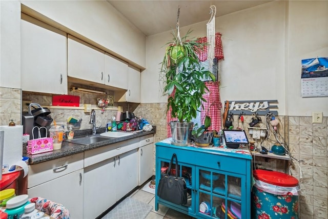 kitchen with backsplash, sink, white cabinets, and light tile patterned floors