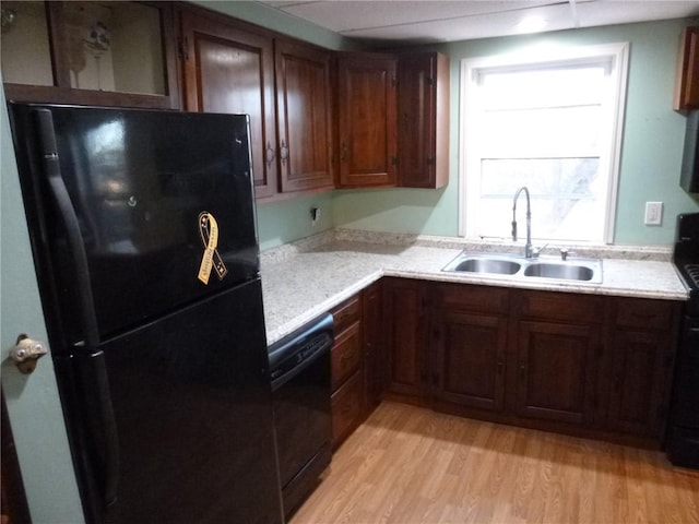 kitchen featuring sink, black appliances, and light hardwood / wood-style floors