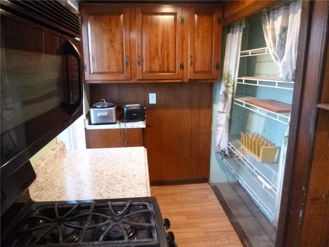 578 Blessing St, Hill District, PA 15213 - kitchen with black microwave, brown cabinets, and light wood-style flooring