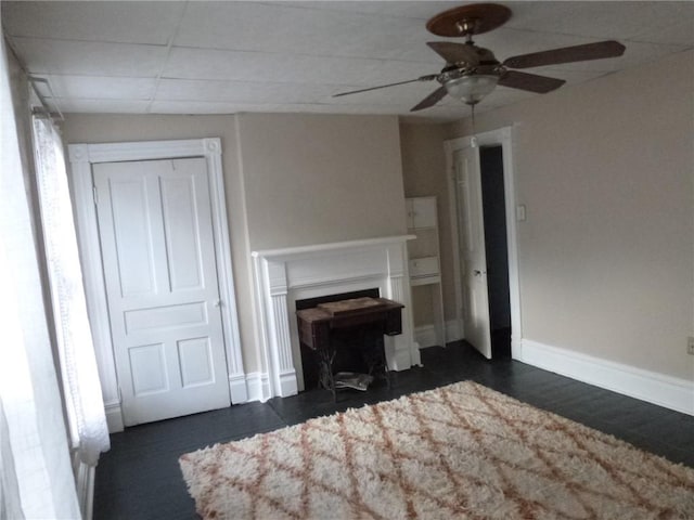 unfurnished living room with ceiling fan and dark hardwood / wood-style floors