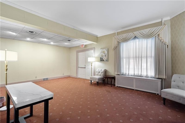 sitting room with radiator heating unit, carpet floors, a drop ceiling, and crown molding