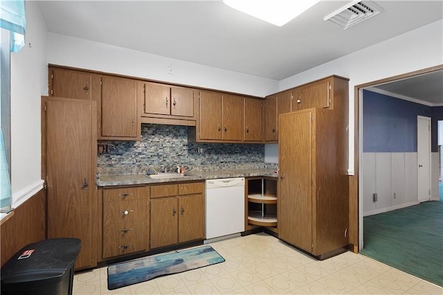 kitchen featuring tasteful backsplash, dishwasher, and sink