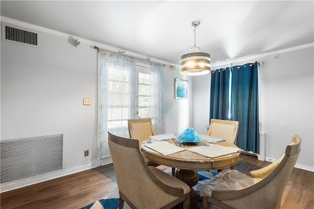 dining space with dark wood-type flooring and ornamental molding