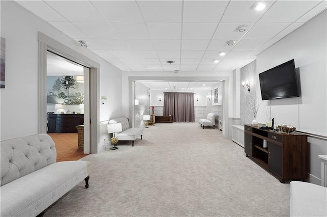 carpeted living room featuring a drop ceiling