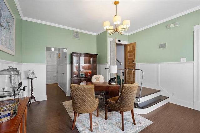 dining space featuring a chandelier, ornamental molding, and dark wood-type flooring