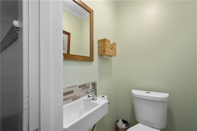 bathroom with backsplash, sink, ornamental molding, and toilet