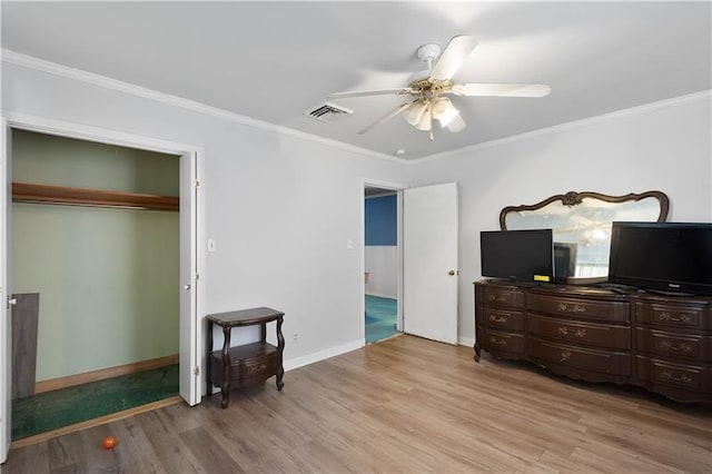 bedroom featuring a closet, light hardwood / wood-style floors, ceiling fan, and ornamental molding