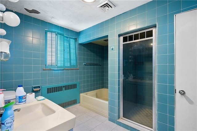 bathroom featuring tile patterned floors, sink, separate shower and tub, tile walls, and radiator heating unit