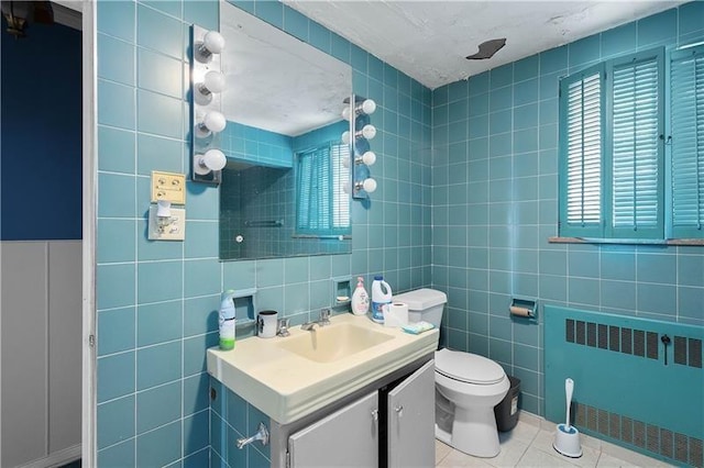 bathroom featuring tile patterned flooring, toilet, tile walls, and radiator