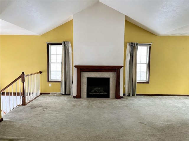 unfurnished living room featuring a fireplace, carpet, and lofted ceiling