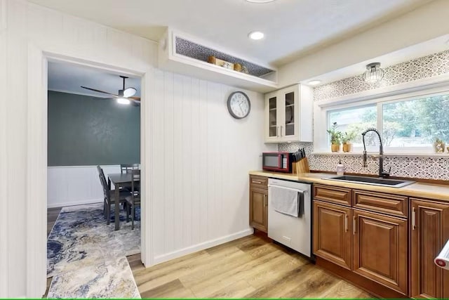 kitchen with dishwasher, sink, ceiling fan, tasteful backsplash, and light hardwood / wood-style floors