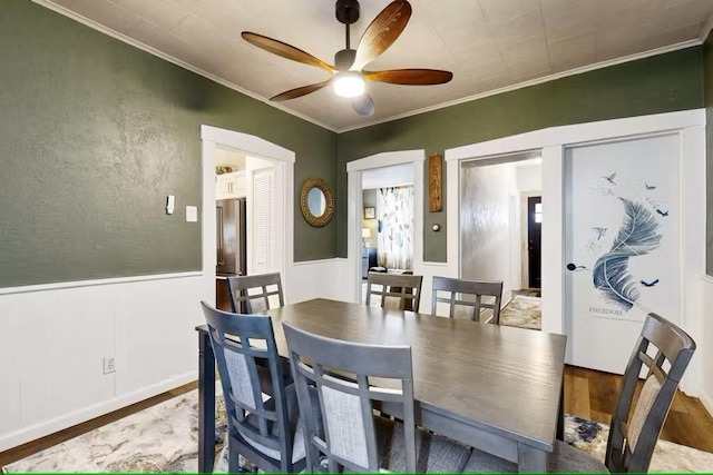 dining room with hardwood / wood-style floors, ceiling fan, and crown molding