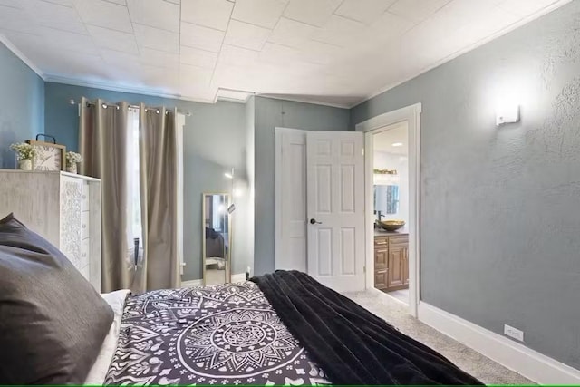 bedroom featuring carpet flooring, crown molding, and ensuite bath