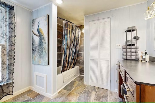 bathroom featuring wooden walls, shower / bath combo with shower curtain, vanity, and a chandelier