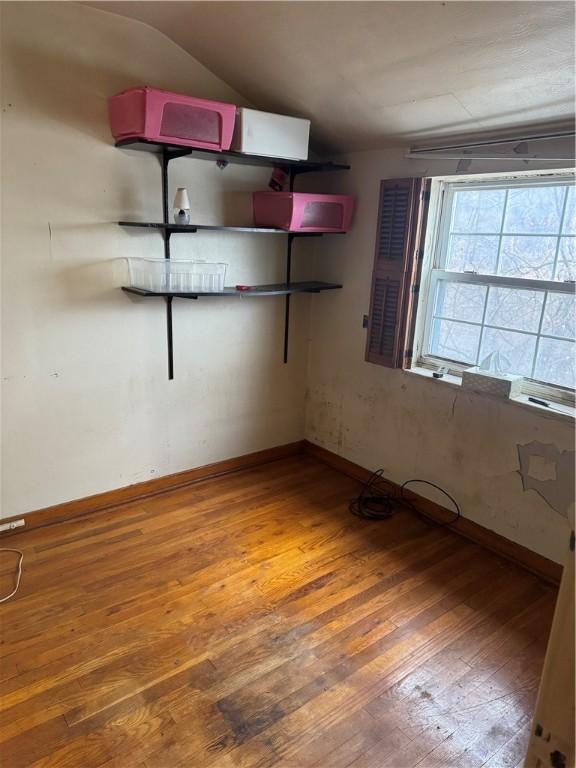 empty room featuring hardwood / wood-style flooring and vaulted ceiling