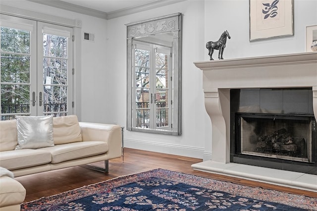 living room featuring french doors, hardwood / wood-style flooring, plenty of natural light, and a tiled fireplace