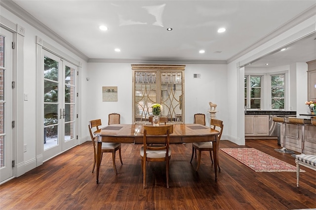 dining space with dark hardwood / wood-style floors, a healthy amount of sunlight, crown molding, and french doors