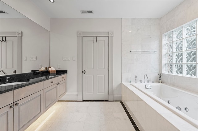 bathroom with vanity and tiled bath