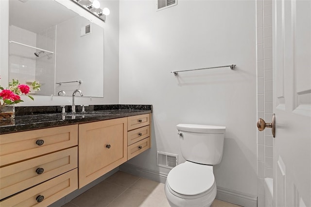 bathroom featuring tile patterned floors, vanity, toilet, and tiled shower