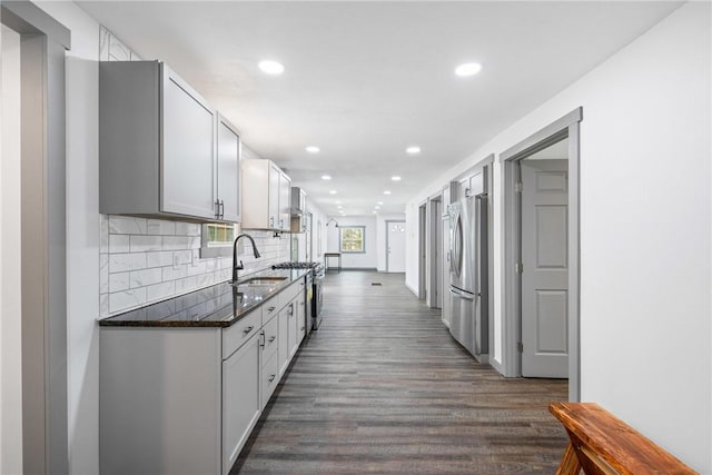 kitchen with stainless steel refrigerator, sink, dark wood-type flooring, tasteful backsplash, and white cabinets