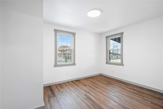 unfurnished room with dark wood-type flooring