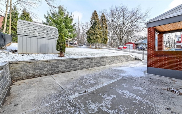 snow covered patio with a storage unit