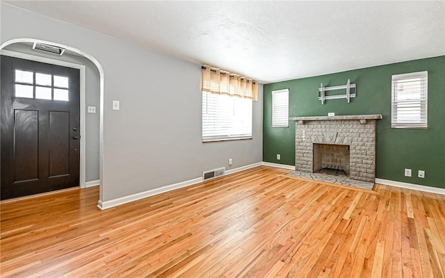 interior space featuring a brick fireplace and light wood-type flooring