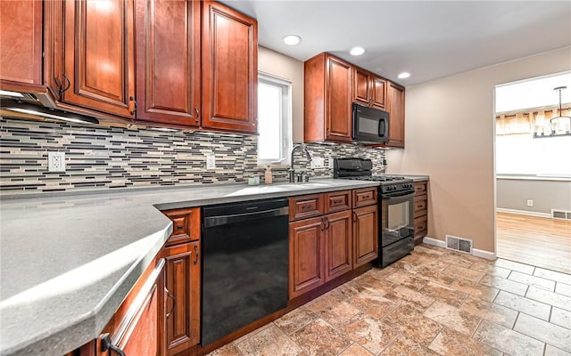 kitchen with black appliances and tasteful backsplash