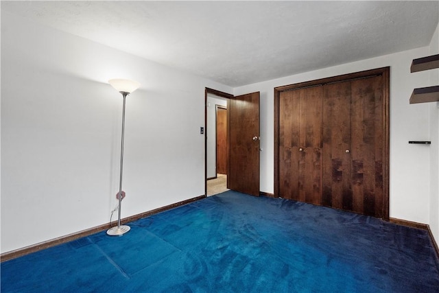 unfurnished bedroom with dark carpet and a closet