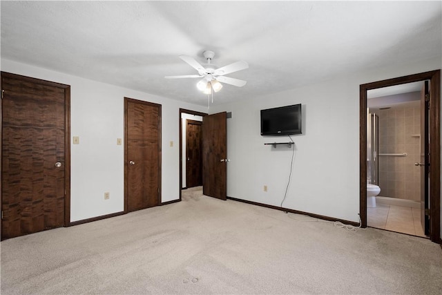 unfurnished bedroom with light carpet, connected bathroom, and ceiling fan