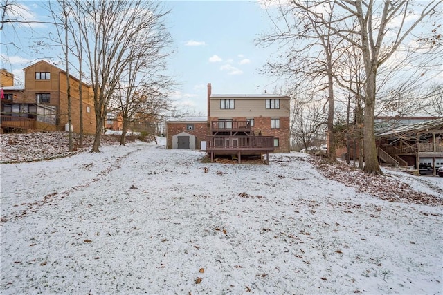 snow covered back of property with a deck