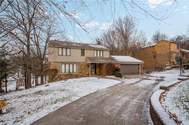 view of front of house with an attached garage, stone siding, driveway, and a chimney