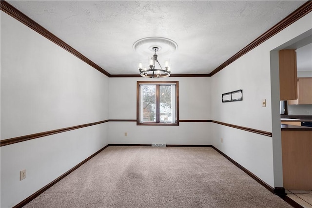 unfurnished room with light carpet, ornamental molding, a textured ceiling, and a notable chandelier