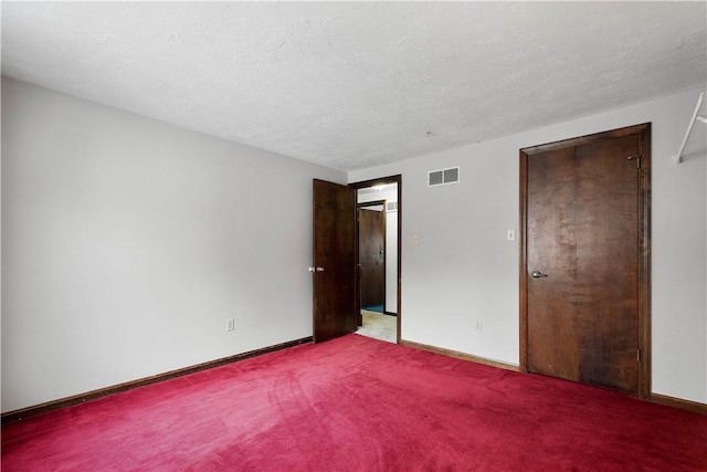 carpeted spare room featuring a textured ceiling