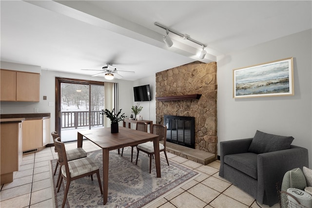 tiled dining area featuring ceiling fan, a fireplace, and track lighting