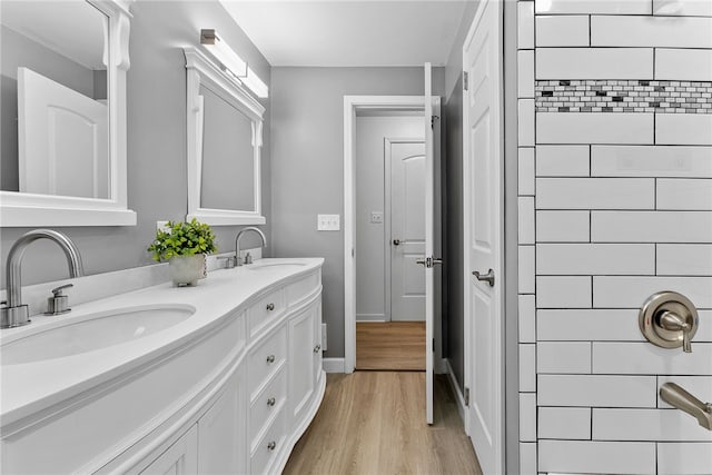 bathroom featuring a tile shower, vanity, and hardwood / wood-style flooring