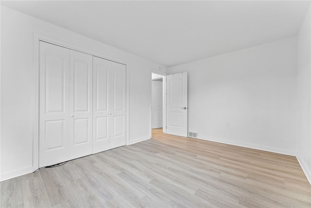 unfurnished bedroom featuring light hardwood / wood-style floors and a closet