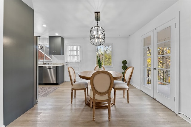 dining room with light hardwood / wood-style flooring, a chandelier, and sink