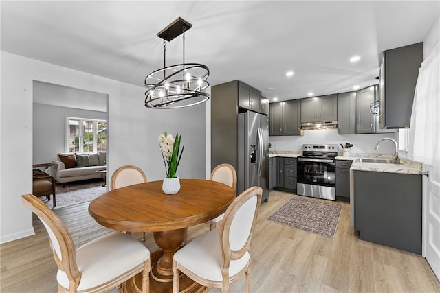 dining area featuring sink, a chandelier, and light hardwood / wood-style flooring